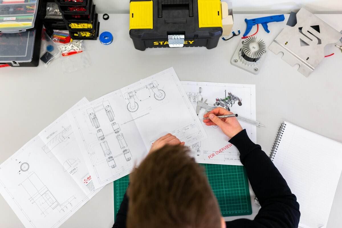 An engineer reviewing technical drawings for a manufacturing client